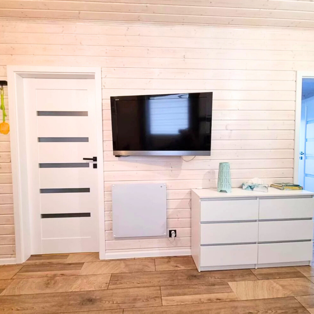 Salon z telewizorem i komodą w domku Patkachatka