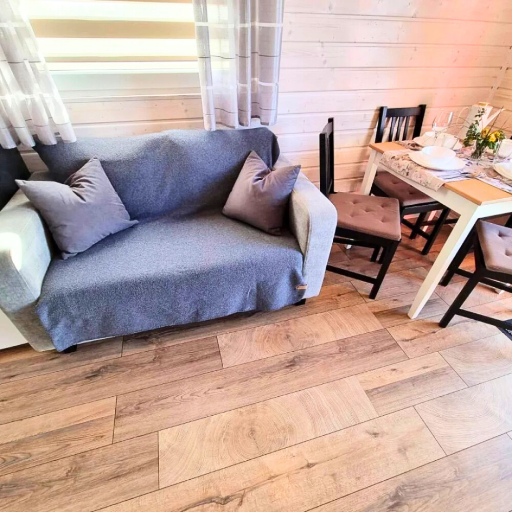 Sofa z poduszkami i jadalnia w domku Patkachatka