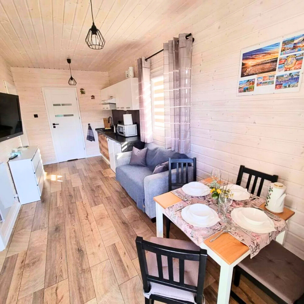Salon z aneksem kuchennym i jadalnią w domku Patkachatka
